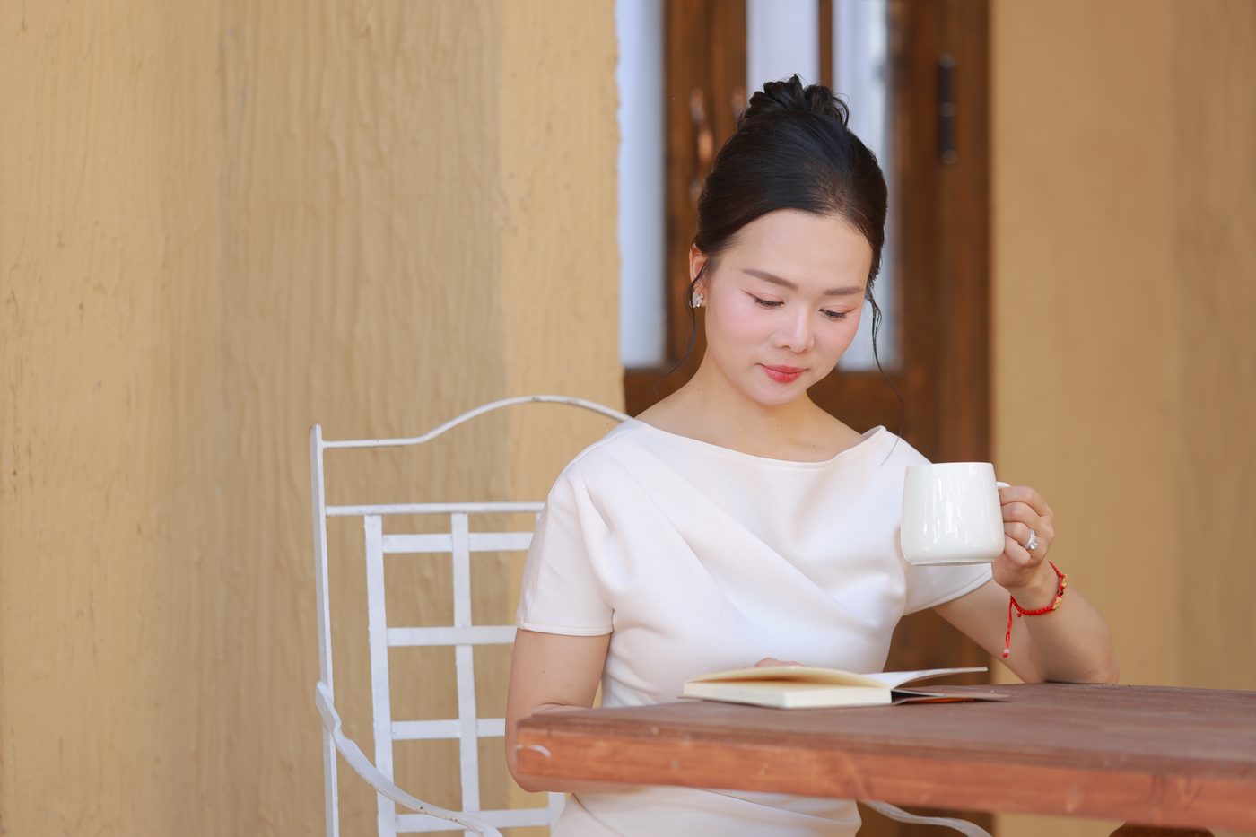 Elsa Phương đọc sách bên tách trà